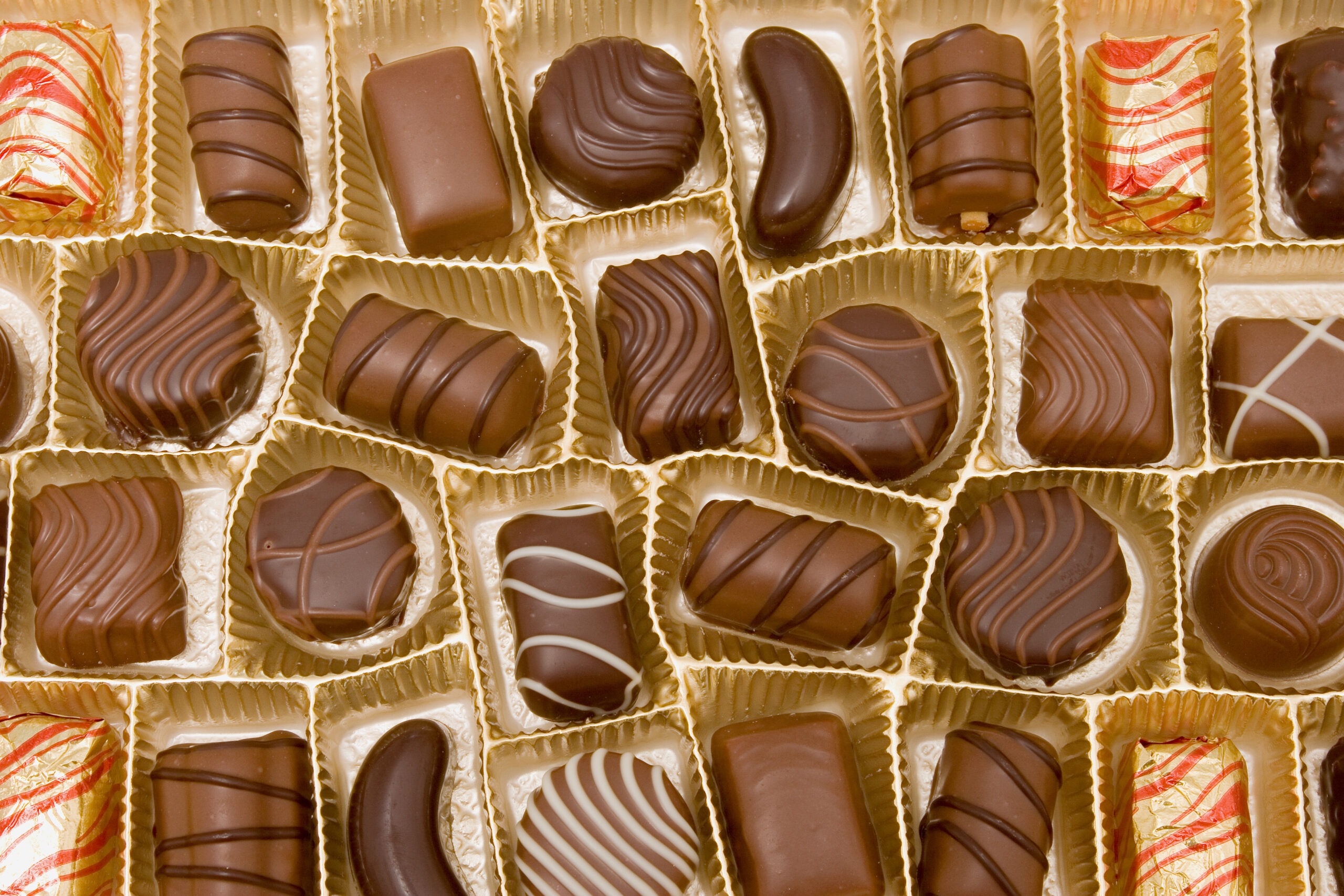 An assortment of chocolates displayed in a golden box