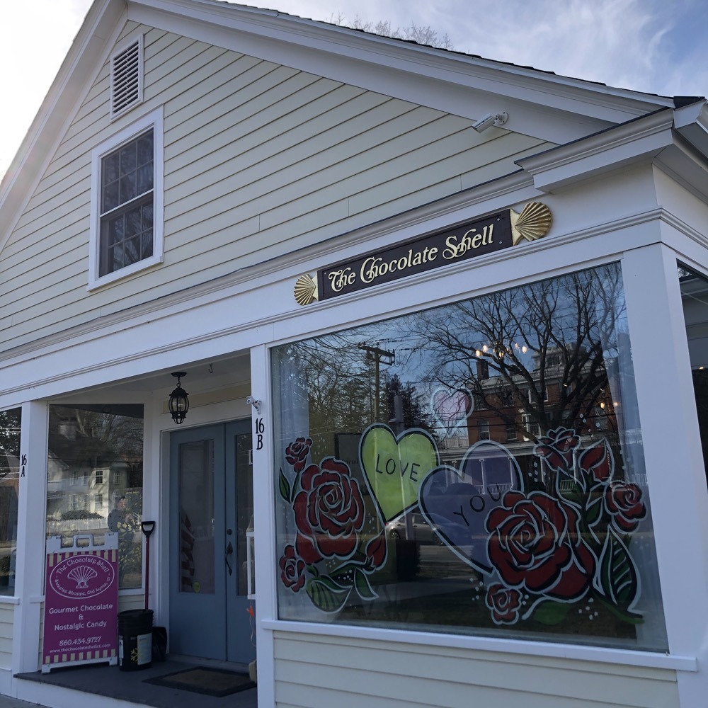 The Chocolate Shell storefront displays a vibrant window mural with roses and colorful hearts